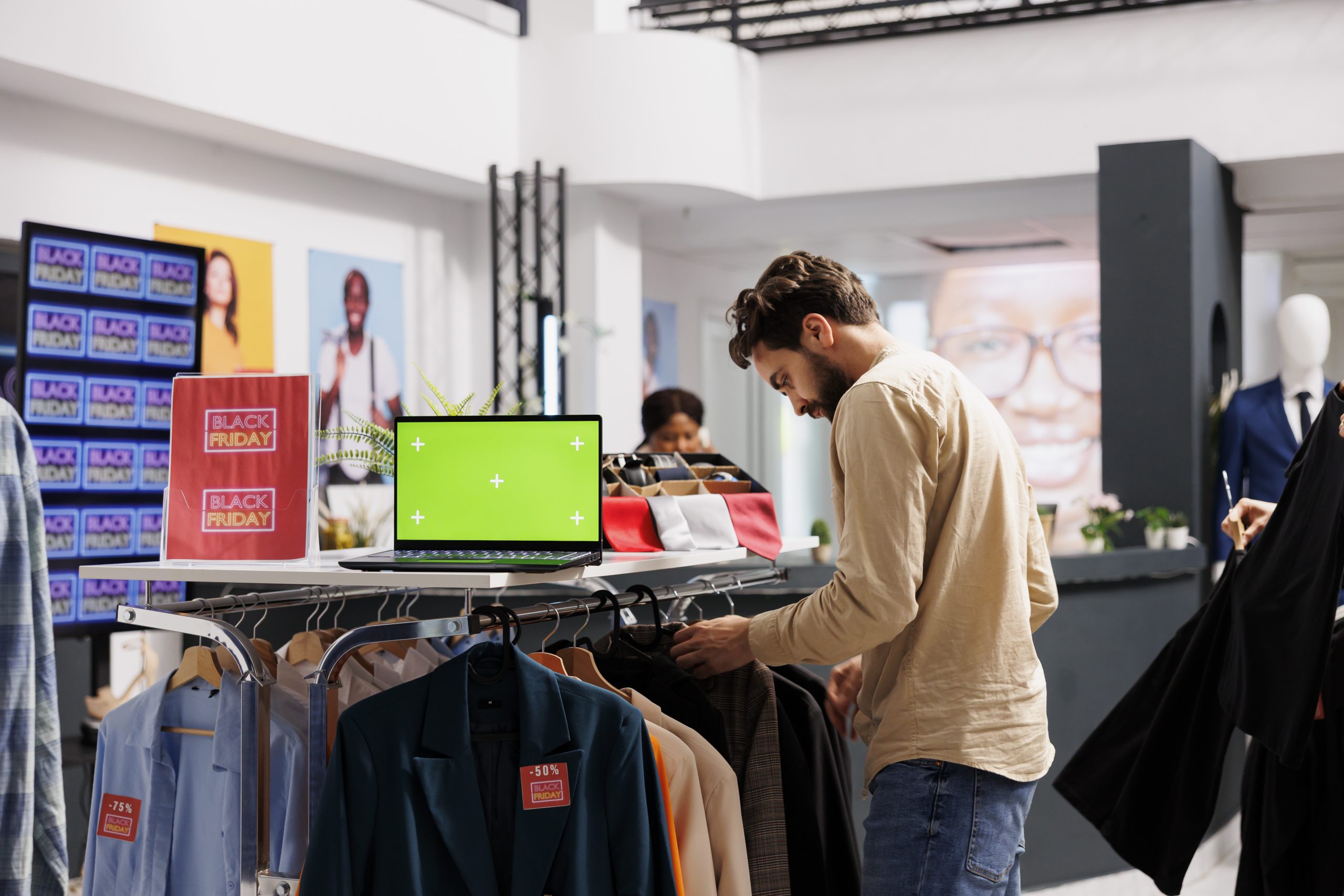 seasonal discounts young man shopping black friday fashion boutique looking discounts holiday season sales laptop with chroma key green screen standing clothing rack 1 scaled