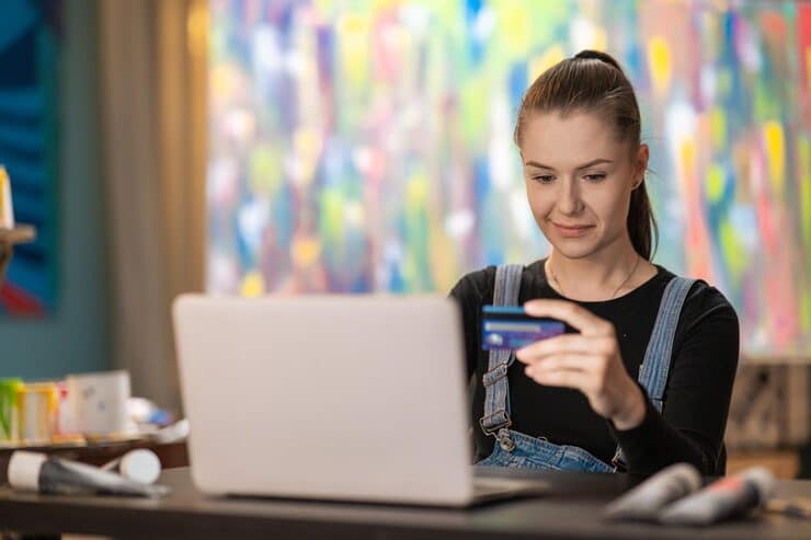 woman sits art store painting studio front computer with credit card debit card pa 616370 4252 1